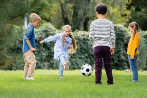 stock-photo-girl-playing-football-friends-blurred-foreground-park