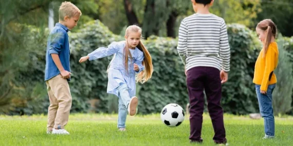 stock-photo-girl-playing-football-friends-blurred-foreground-park